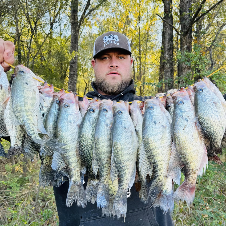 Caleb of 903 Fishing holding a stringer of crappie