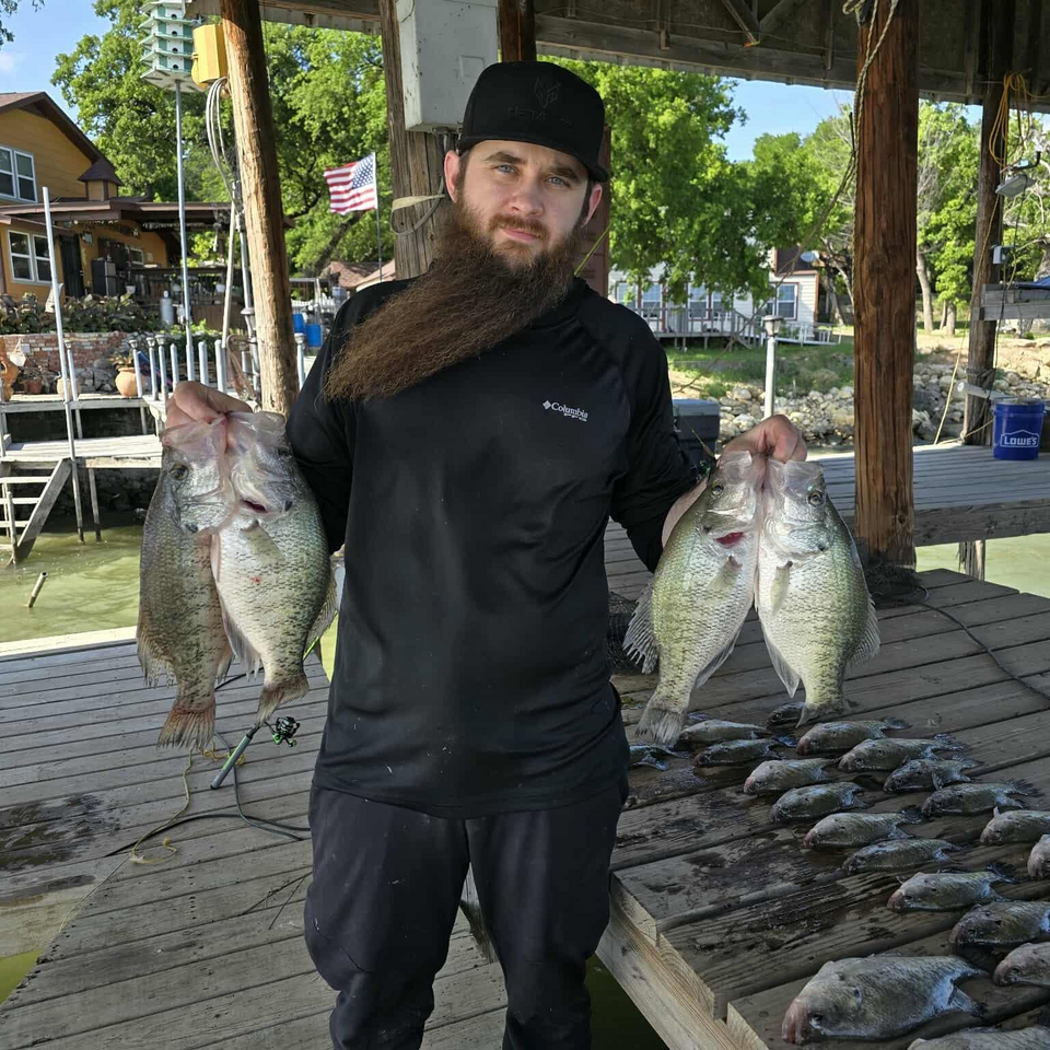 Dustin Arnold holding crappie on a fishing dock